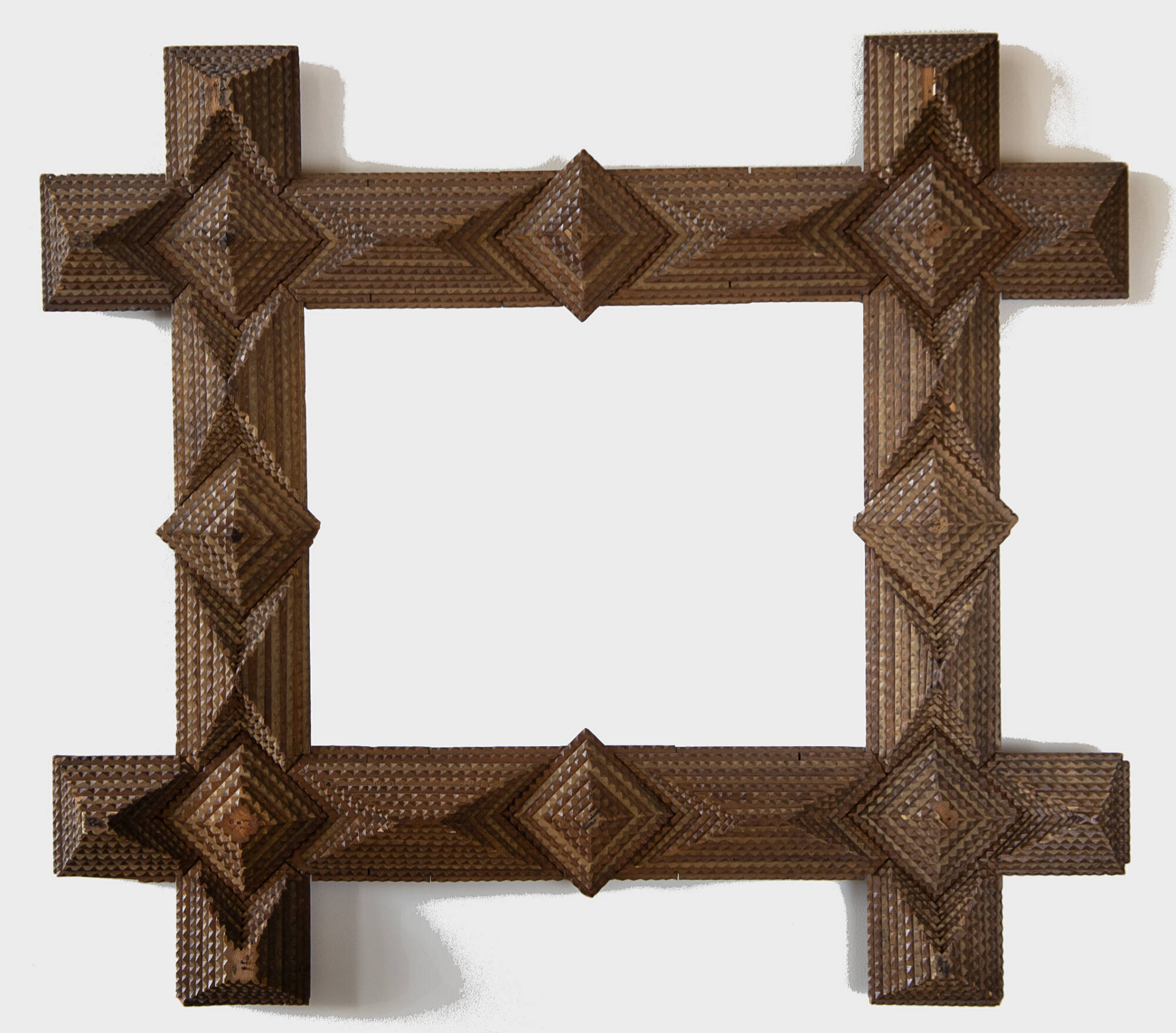 Carved wooden rectangular frame with a diamond shaped pattern.